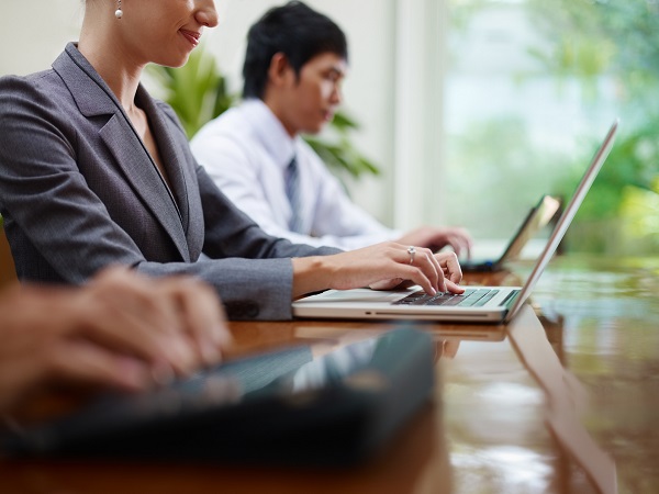 business man and women typing on pc during meeting